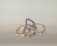 a stack of purple and yellow beads on a table